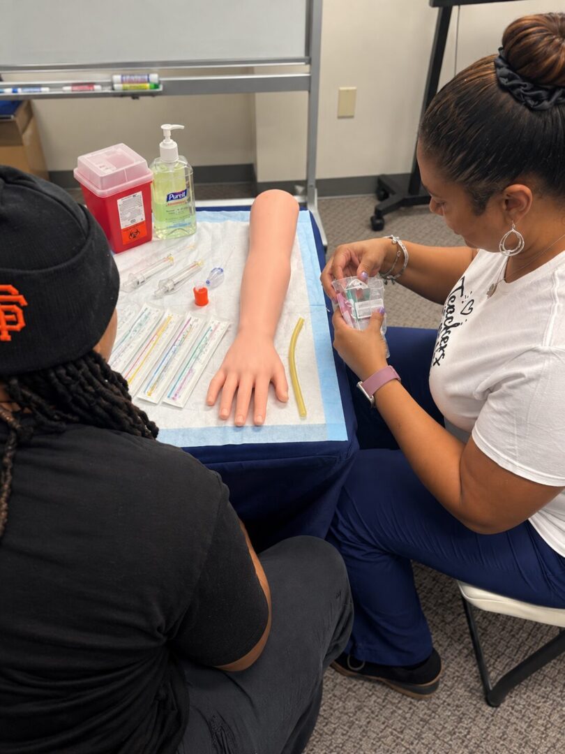 Medical training with simulation arm and supplies.